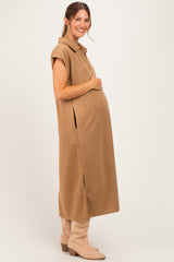 woman wearing a tan sleeveless maternity dress with side slits and a baby bump visible