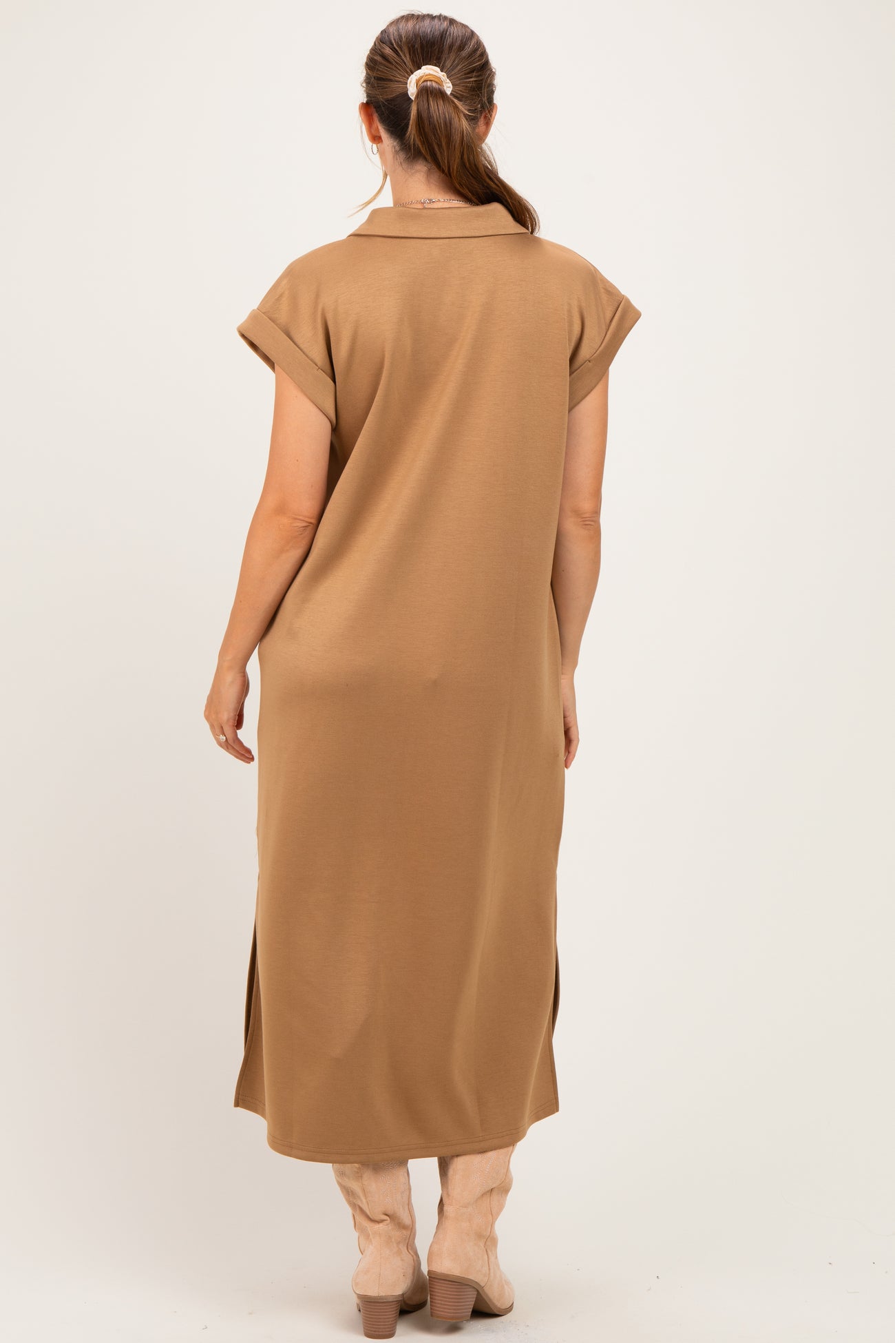 woman wearing a brown maternity dress with short sleeves and side slits, showing a relaxed fit from the back