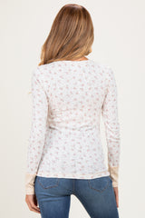 woman wearing a floral long sleeve maternity top with a fitted style and back view, paired with blue jeans