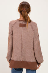 woman wearing a brown striped oversized sweater with raglan sleeves and a contrasting hem, shown from the back