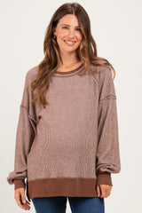 woman wearing a striped brown oversized maternity sweater with long sleeves and a relaxed fit, showing a baby bump