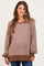 woman wearing a striped brown oversized maternity sweater with long sleeves and a relaxed fit, showing a baby bump