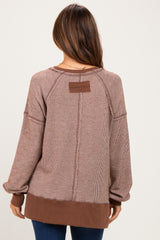 woman wearing a brown striped maternity sweatshirt with a relaxed fit and contrasting color hem
