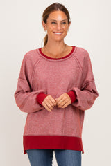 woman wearing a red and white striped long sleeve pullover sweater with a relaxed fit and ribbed cuffs