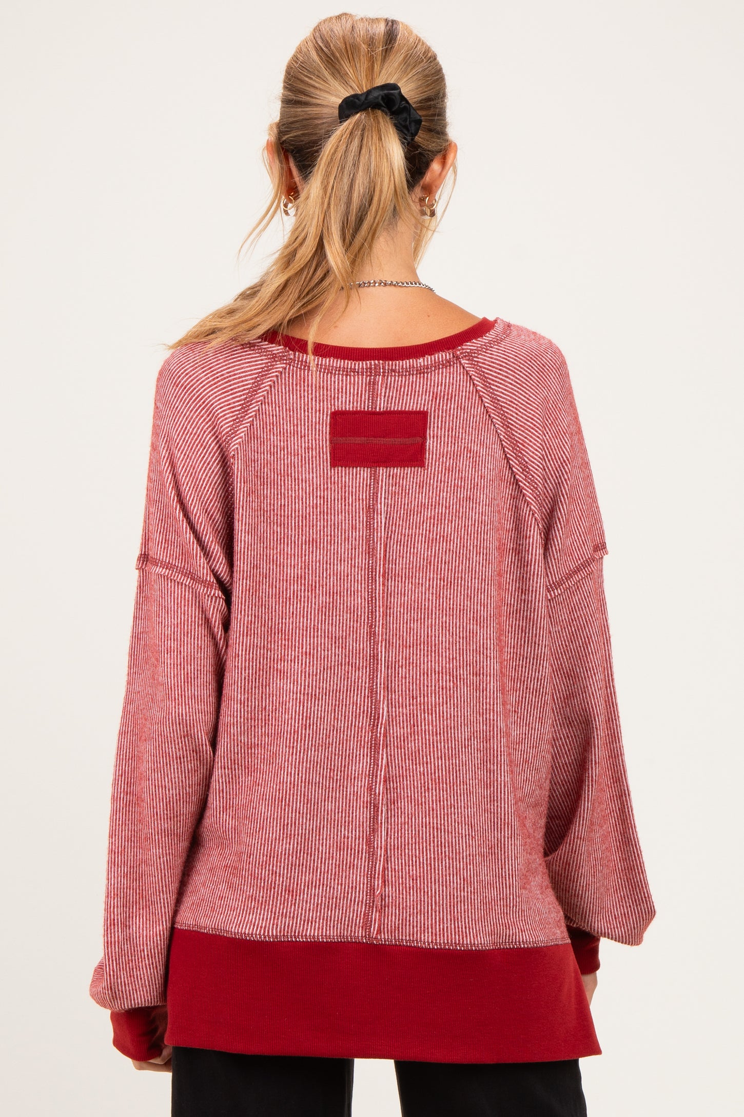 woman wearing a red and white striped maternity sweater with a relaxed fit and back detailing