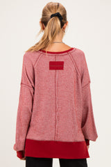 woman wearing a red and white striped maternity sweater with a relaxed fit and back detailing