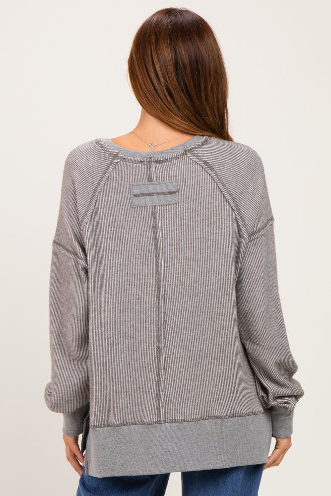 woman wearing a gray ribbed oversized sweatshirt with a back seam detail and drop shoulder sleeves