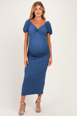 woman wearing a blue puff sleeve maternity dress with a fitted silhouette and a baby bump visible