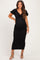 woman wearing a black maternity dress with a knot front and short puff sleeves, showcasing her baby bump
