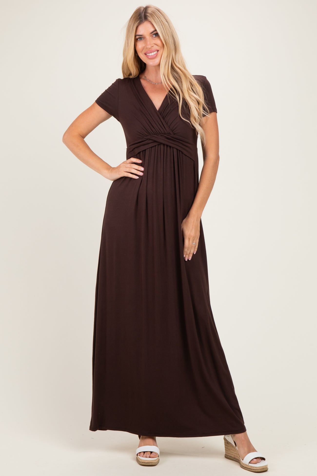 woman wearing a dark brown short sleeve maxi dress with a wrap-style bodice and gathered waist detail