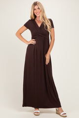 woman wearing a dark brown short sleeve maxi dress with a wrap-style bodice and gathered waist detail