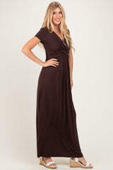 woman wearing a brown short sleeve maxi dress with a twisted front detail and wedge sandals