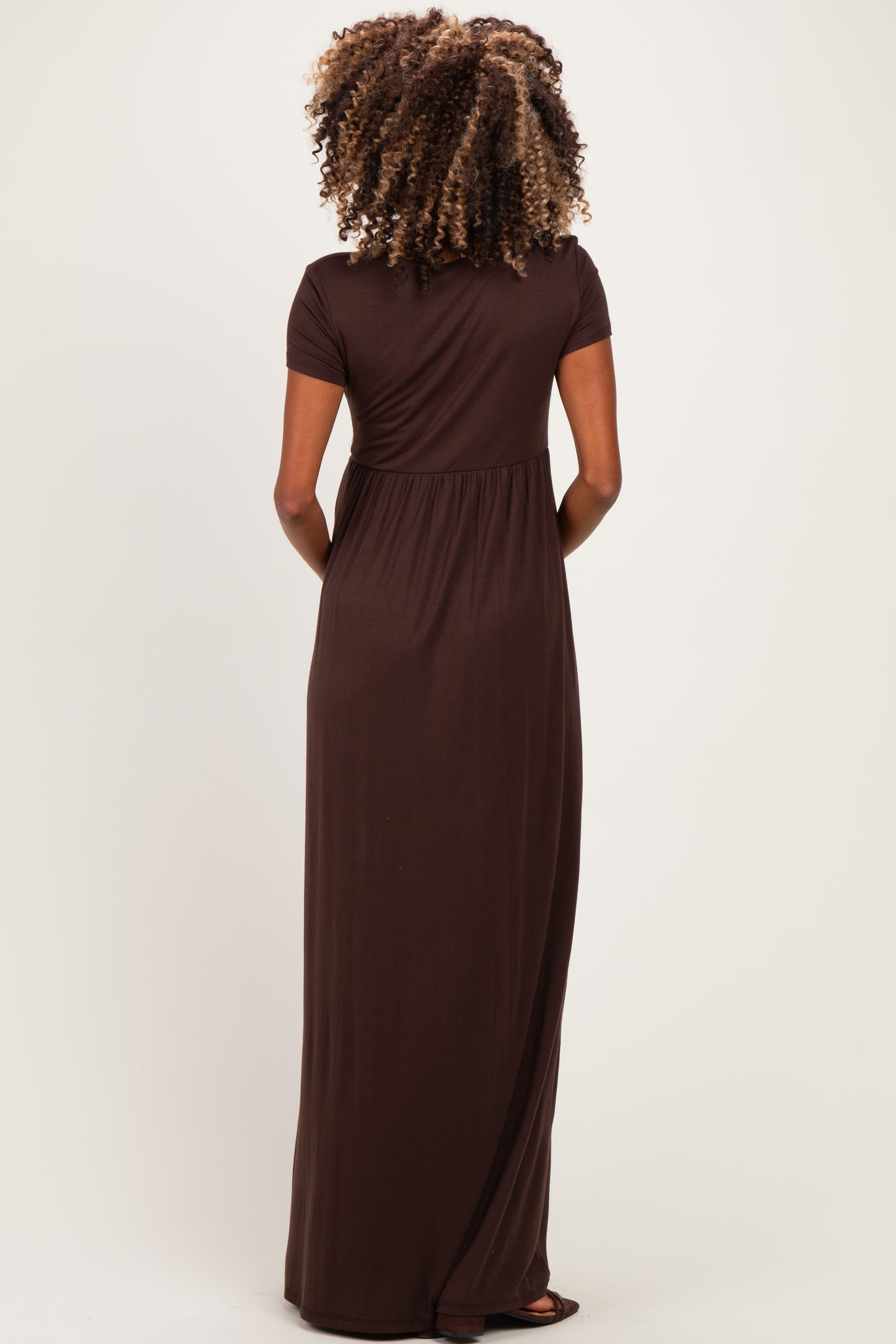 woman wearing a brown short sleeve maternity maxi dress, showing the back view with a relaxed fit