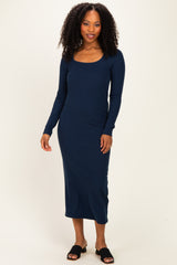woman wearing a navy long sleeve ribbed dress with a scoop neckline and black slide sandals