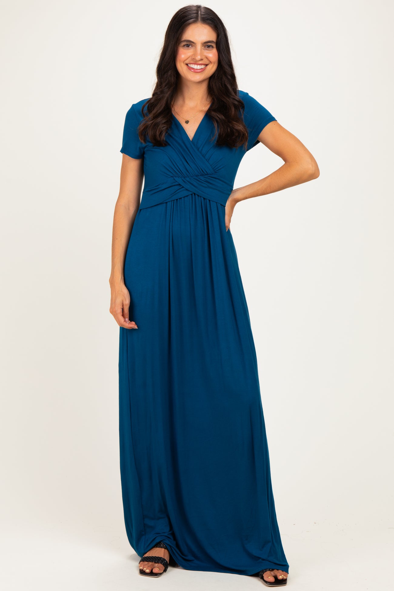 woman wearing a teal short sleeve maxi dress with a twisted front detail and a relaxed fit