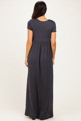 woman wearing a dark gray short sleeve maxi dress with a gathered waist and flowy skirt