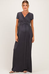 woman wearing a dark gray short sleeve maternity maxi dress with a cross-over front and baby bump visible