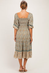 woman wearing a floral print maternity dress with a square neckline and puff sleeves, showing the back view