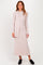 woman wearing a light beige long sleeve ribbed maxi dress with a tie detail and black slip-on shoes