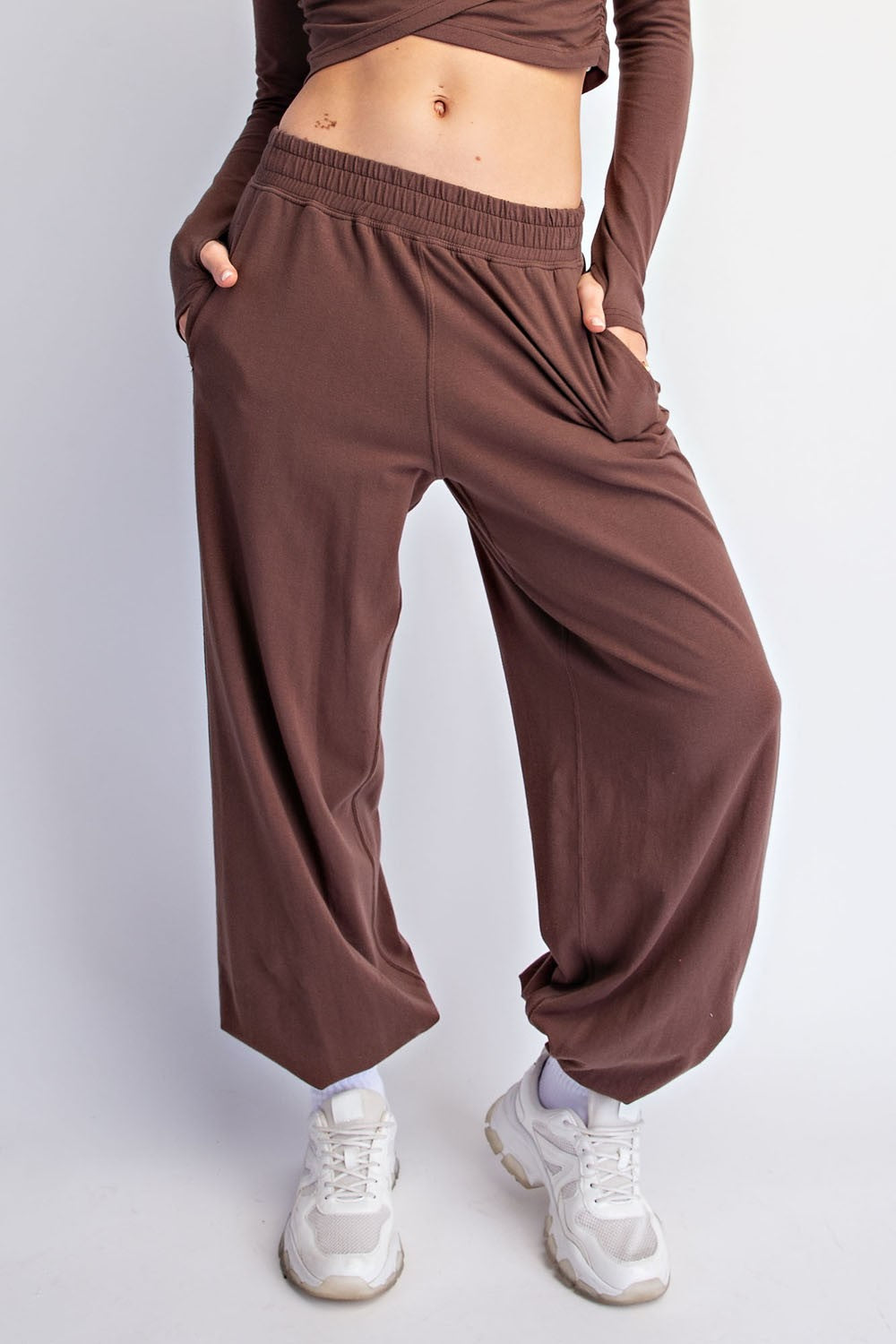 woman wearing brown wide-leg pants with side pockets and a fitted long sleeve top