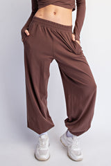woman wearing brown wide-leg pants with side pockets and a fitted long sleeve top