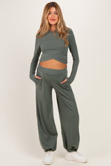 woman wearing a green long sleeve maternity top and matching wide-leg maternity pants with pockets