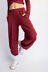 woman wearing burgundy wide-leg pants with pockets and white sneakers