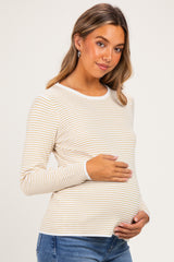 woman wearing a cream and mustard striped long sleeve maternity top and holding her baby bump