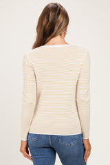 woman wearing a cream and yellow striped long sleeve maternity top, shown from the back with casual blue jeans