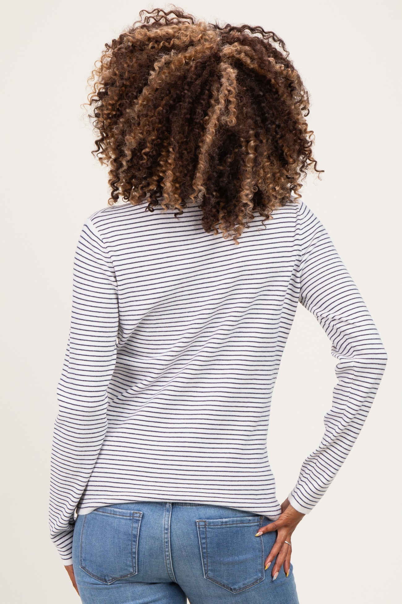 woman wearing a striped maternity long sleeve top with a fitted style and a baby bump visible from the back