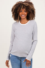 woman wearing a striped maternity top with long sleeves and a visible baby bump, paired with light blue jeans