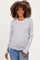 woman wearing a striped maternity top with long sleeves and a visible baby bump, paired with light blue jeans