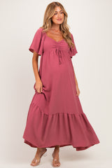 woman wearing a dusty rose maternity maxi dress with flutter sleeves and a ruffled hem, showcasing her baby bump
