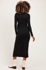 woman wearing a black long sleeve maternity dress, showing a fitted silhouette from the back