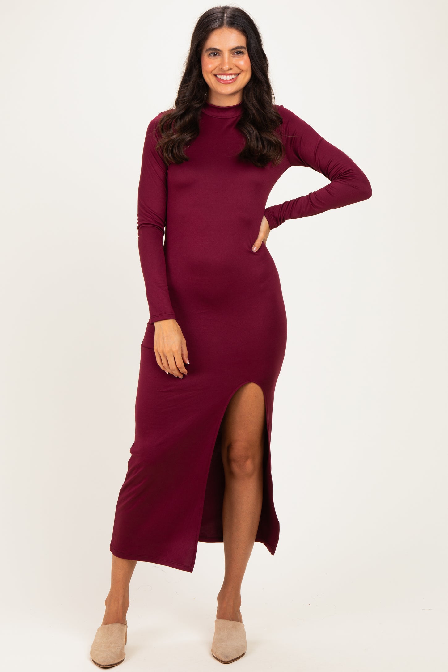 woman wearing a burgundy long sleeve midi dress with a side slit and a relaxed fit
