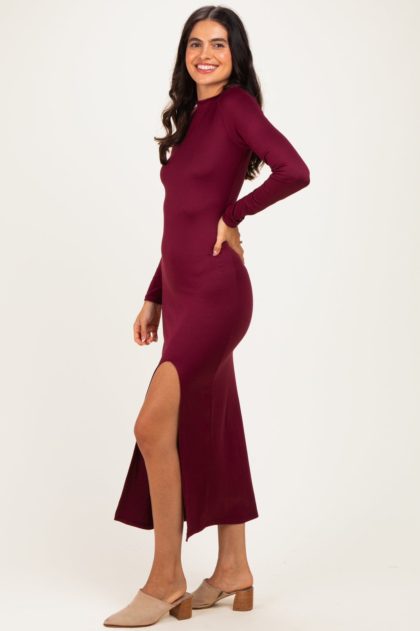 woman wearing a burgundy long sleeve maxi dress with a side slit and beige block heels