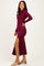woman wearing a burgundy long sleeve maxi dress with a side slit and beige block heels