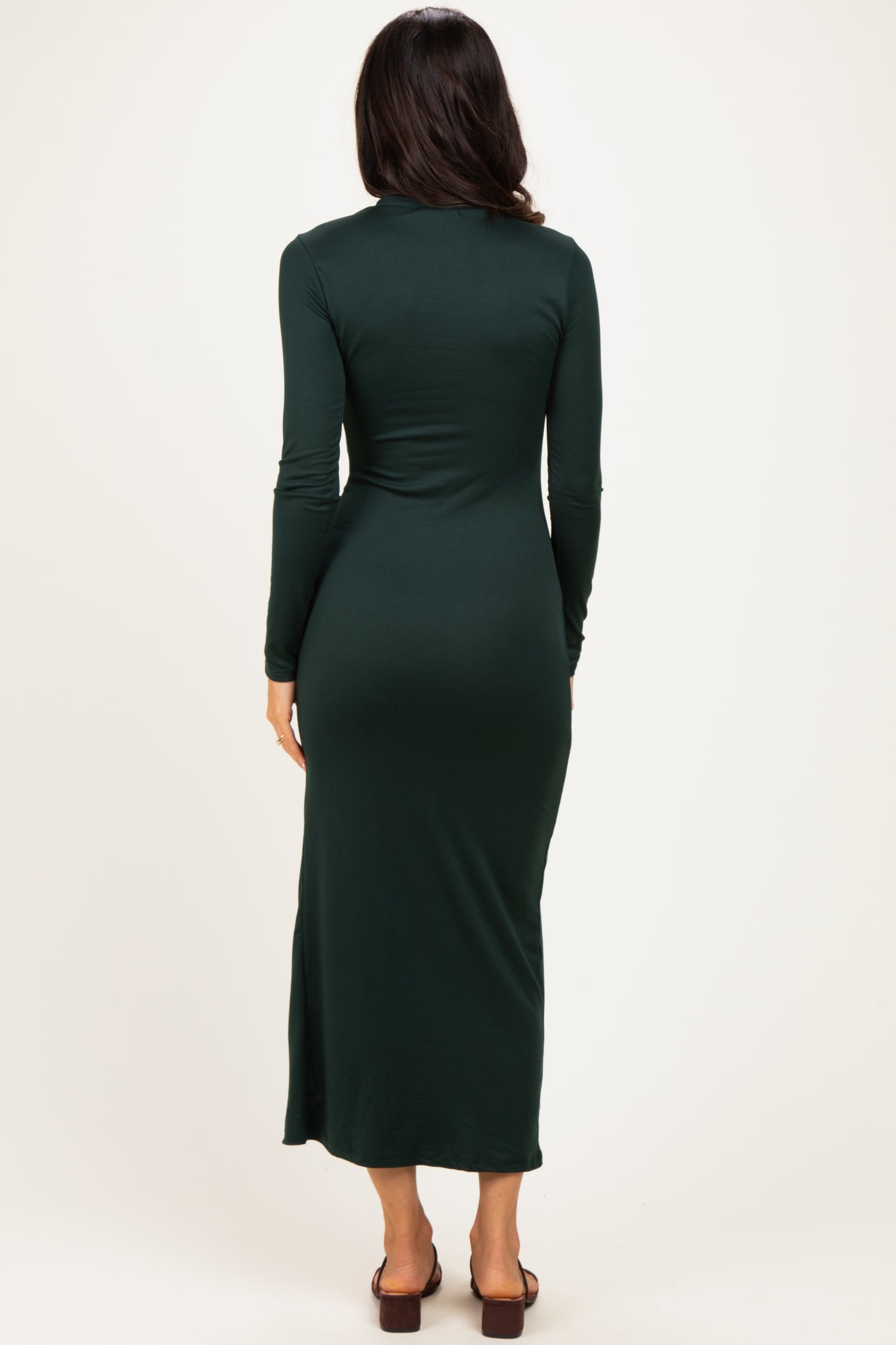 woman wearing a long sleeve dark green maxi dress, viewed from the back