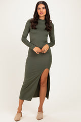 woman wearing an olive green long sleeve maxi dress with a side slit and a fitted silhouette