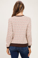 woman wearing a striped maternity sweater with a relaxed fit and long sleeves, seen from the back
