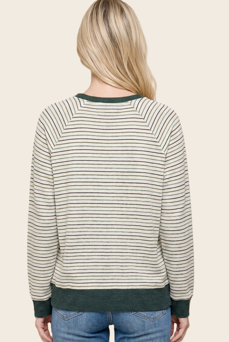 woman wearing a beige and green striped pullover sweater, showcasing the back with long sleeves and a relaxed fit
