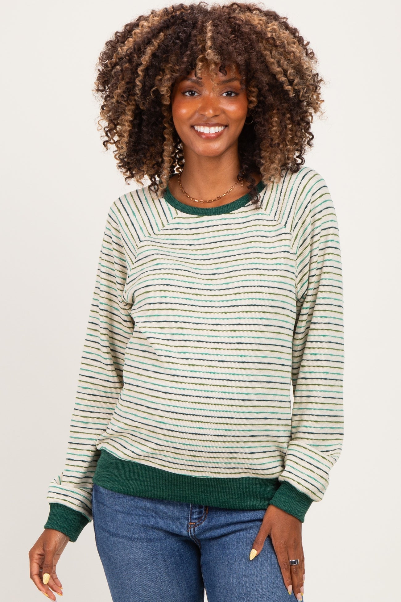 woman wearing a cream and green striped maternity sweatshirt with long sleeves and a relaxed fit