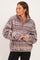 woman wearing a cozy brown and pink patterned fleece pullover with a half zipper and relaxed fit