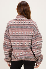 woman wearing a patterned oversized fleece pullover in shades of pink and gray, shown from the back
