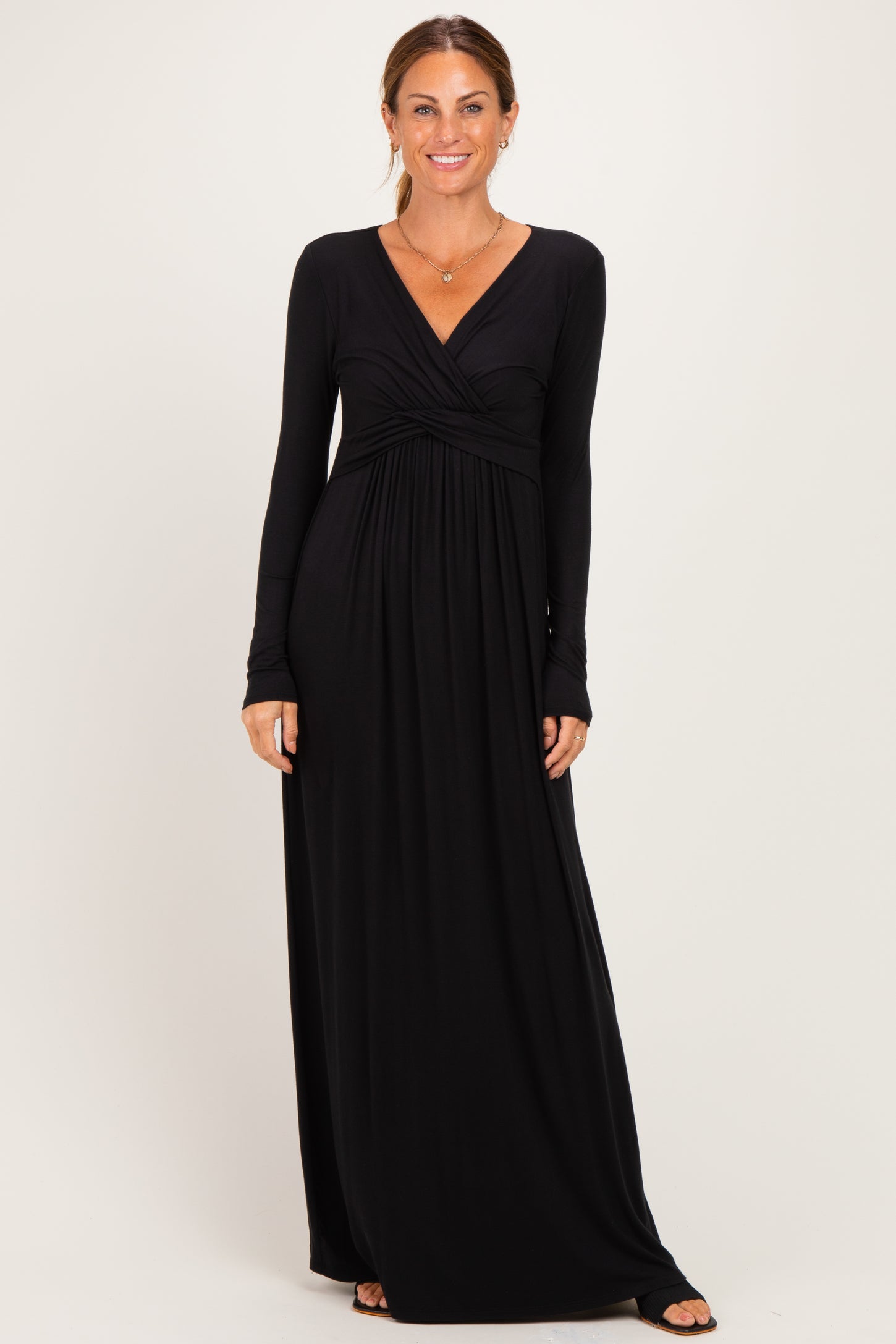 woman wearing a black long sleeve maxi dress with a wrap-style bodice and gathered waist detail