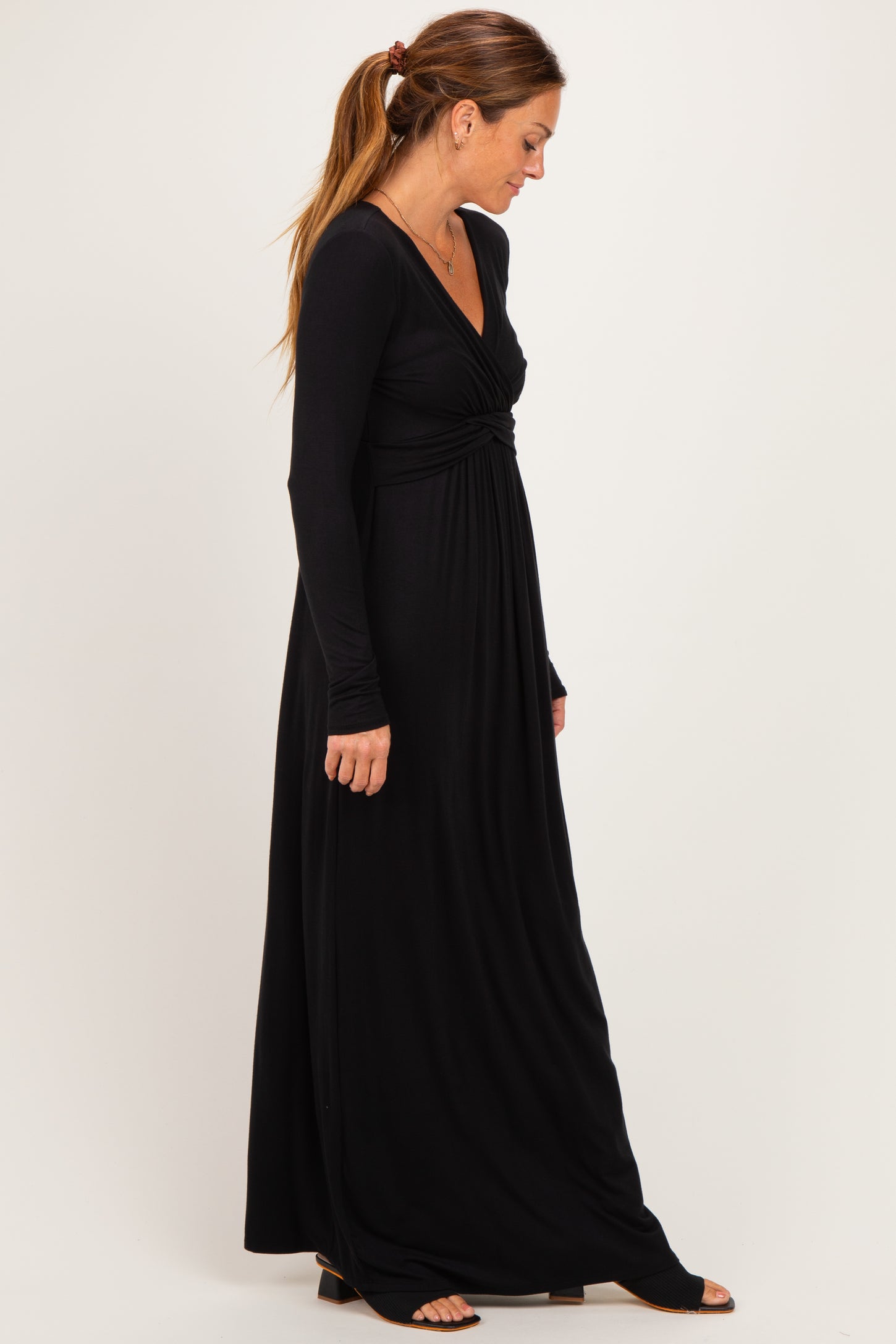 woman wearing a black long sleeve maxi dress with a twisted front detail
