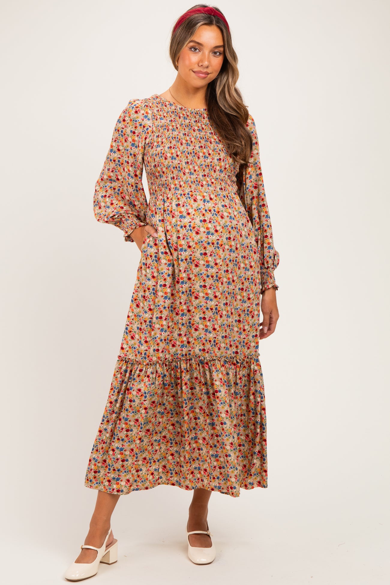 woman wearing a floral pattern maternity maxi dress with puff sleeves and pockets, featuring a smocked bodice