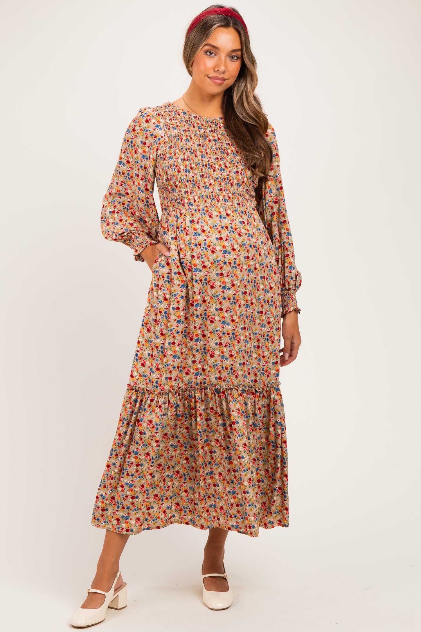 woman wearing a floral pattern maternity maxi dress with puff sleeves and pockets, featuring a smocked bodice