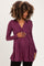 woman wearing a purple long sleeve maternity top and holding her baby bump