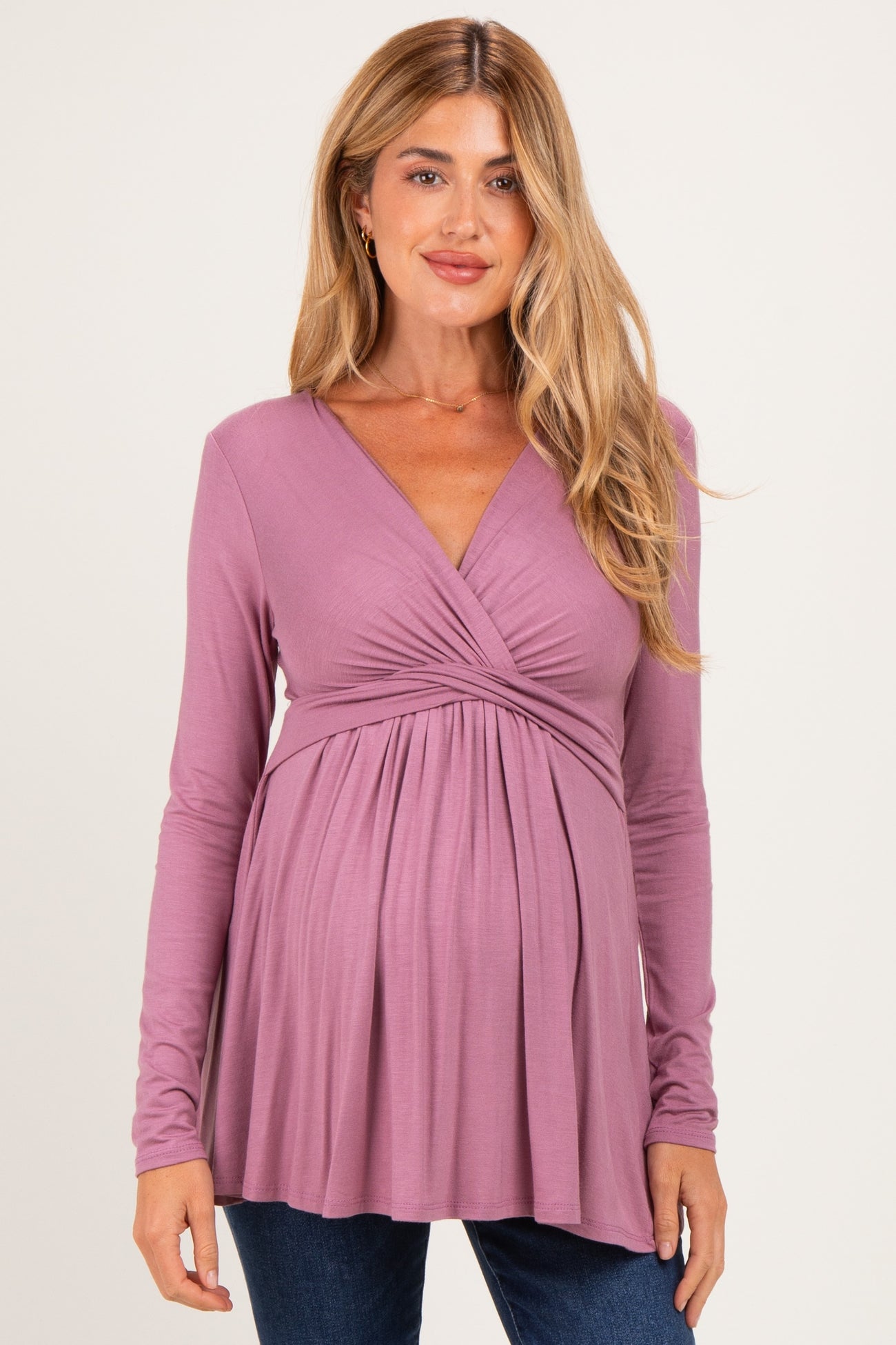 woman wearing a mauve long sleeve maternity top with a cross-over v-neck and empire waist, showing a baby bump